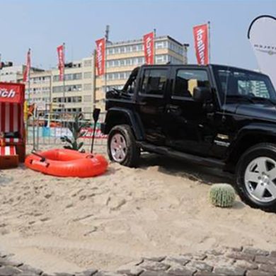 X-Zone Aufbau Beachinsel mit Strandkorb und Beachflags, dabei steht ein Fahrzeug